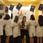 Staff posing with certificates in front of business sign, AE Aesthetic Medi Specialist, George Town