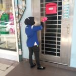 Worker in uniform wiping a metal door grille, Cleaning Resources Malaysia, Puchong