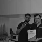 Two staff in uniform holding a hair restoration brochure, DHI Malaysia, Petaling Jaya