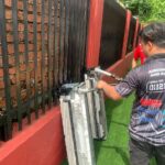 Technician servicing an air conditioning unit outdoors, ERZ Teguh Aircond Service, Petaling Jaya
