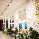 Marble-clad hotel lobby corridor with plants and welcome sign, Hotel Salaam Suites, Kota Bharu