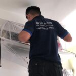 Technician cleaning an air conditioning unit indoors, My Air Conditioning Services Sdn Bhd, Batu