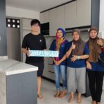 Team posing with company sign in a kitchen, PT CLEAN Services, Cheras (Kuala Lumpur)