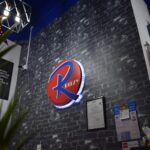 Illuminated logo sign on brick wall inside salon, Ritzy RS, Subang Jaya
