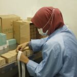 Worker packing product boxes at a factory table, Sireh Emas Marketing Sdn.Bhd, Shah Alam
