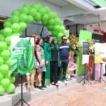 People posing at storefront opening with balloon arch, Tini's Spa, Ampang